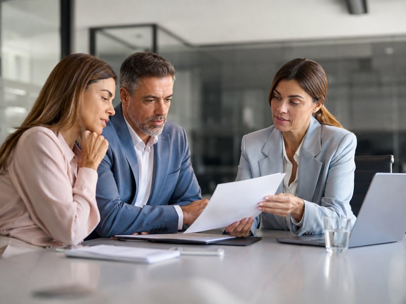 Business colleagues reviewing documents together at a conference table, representing a coverage review