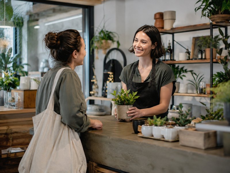 A small business owner helping a customer at a retail shop counter